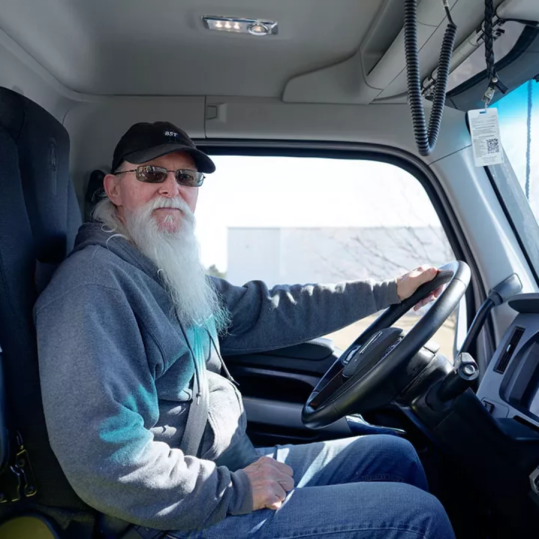 BST truck driver sitting inside semi-truck cab preparing for delivery