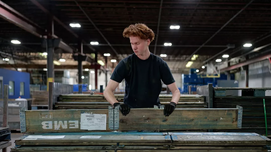 Warehouse worker pushing pallet load through distribution center