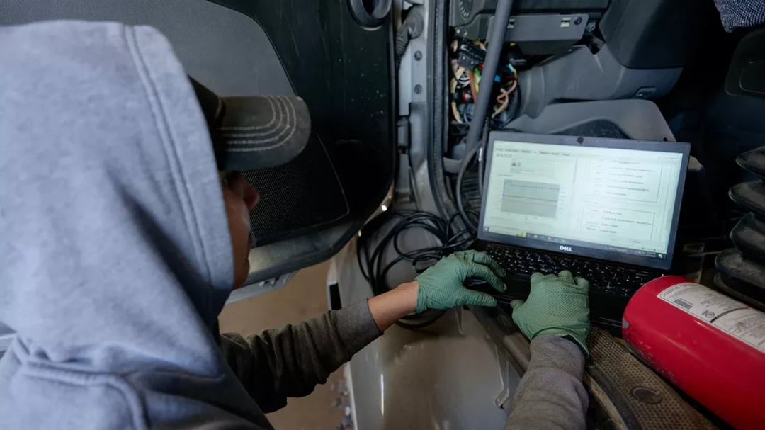 Technician running diagnostic test on semi-truck engine system