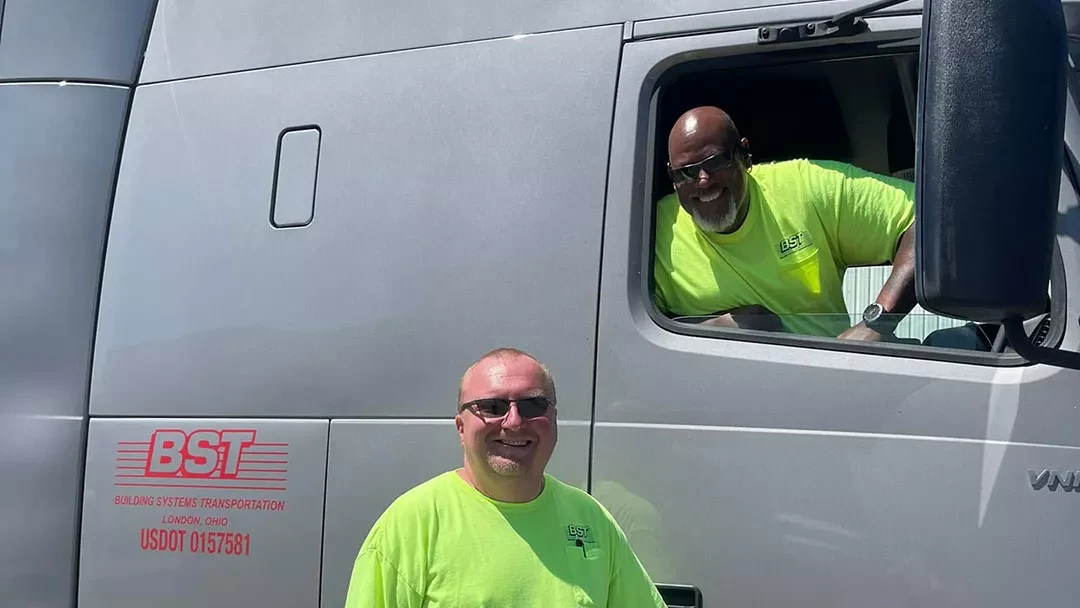 BST truck driver smiling from semi-truck cab window